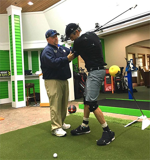 Golf instructor critiquing golfer's swing biomechanics