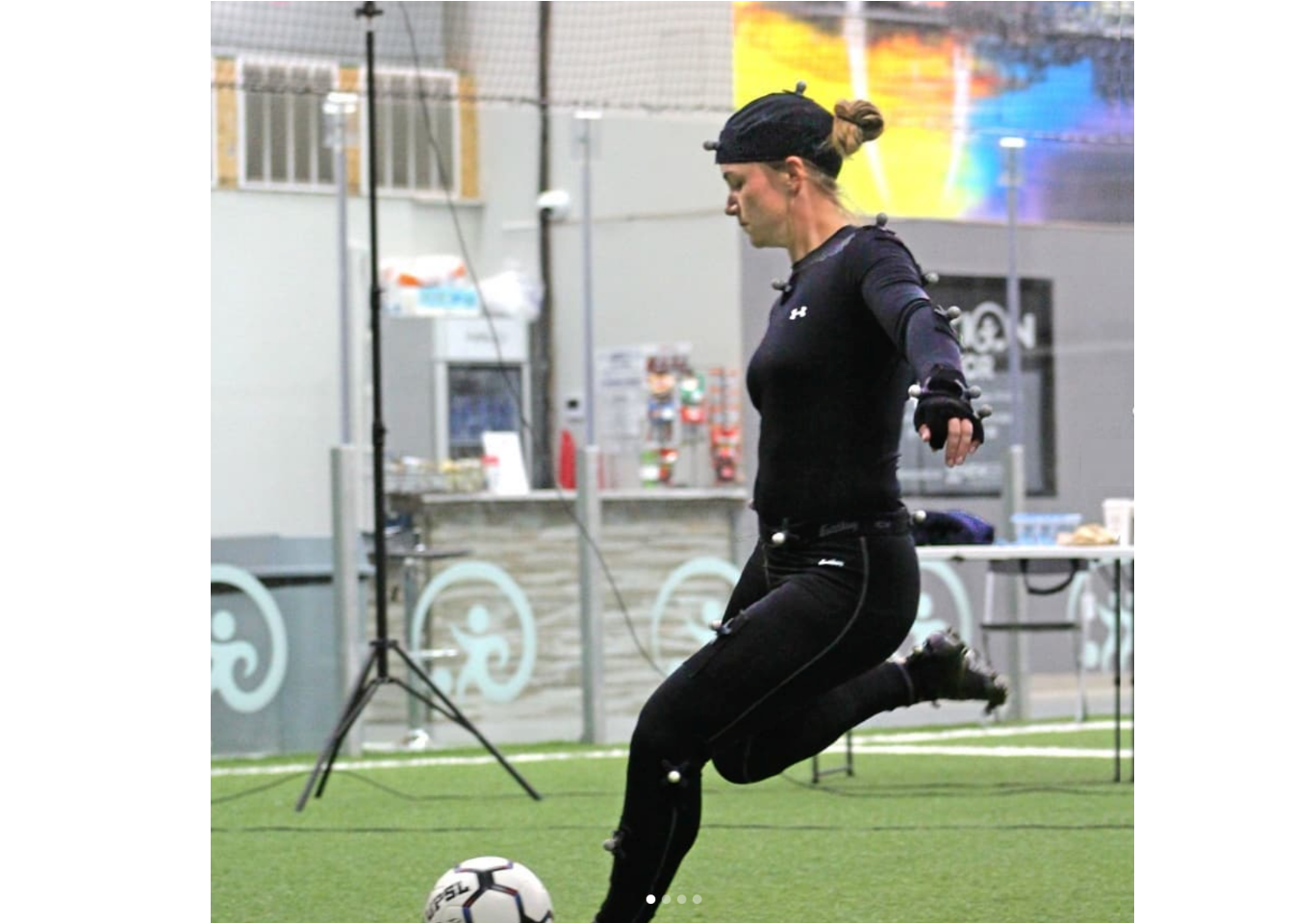 woman in mocap compression suit kicking a soccer ball