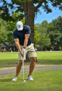 Experienced golfer hits with the interlocking golf grip