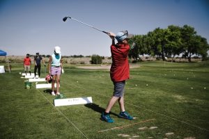 Young man practices weight transfer in golf swing