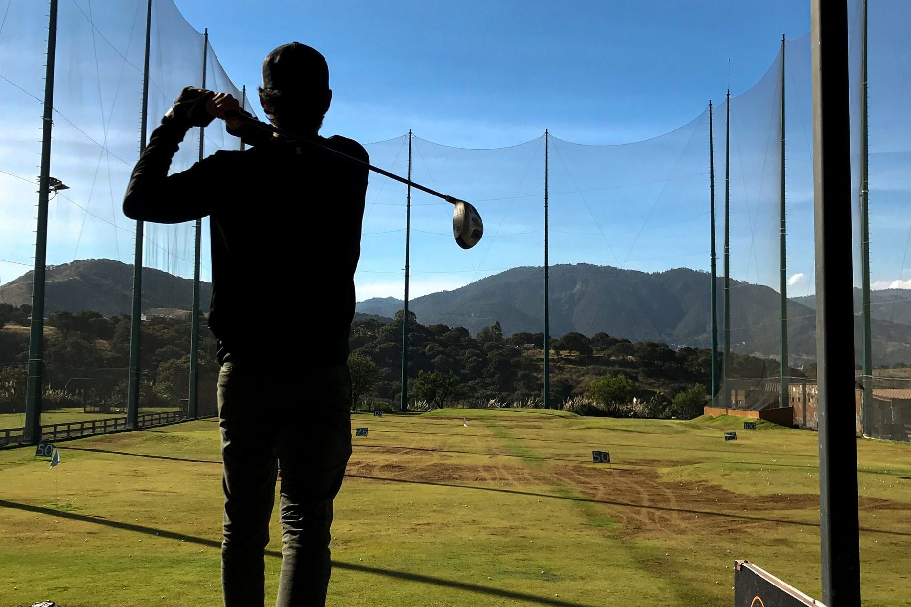 golfer hitting ball across driving range