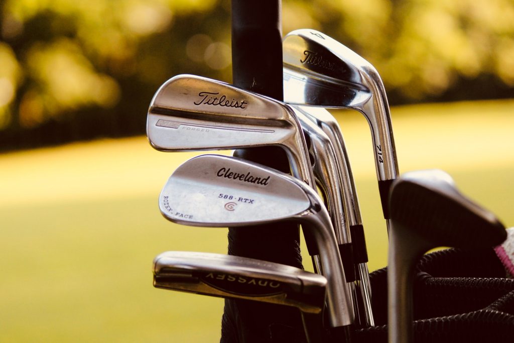 A golf bag with freshly cleaned golf clubs on a course