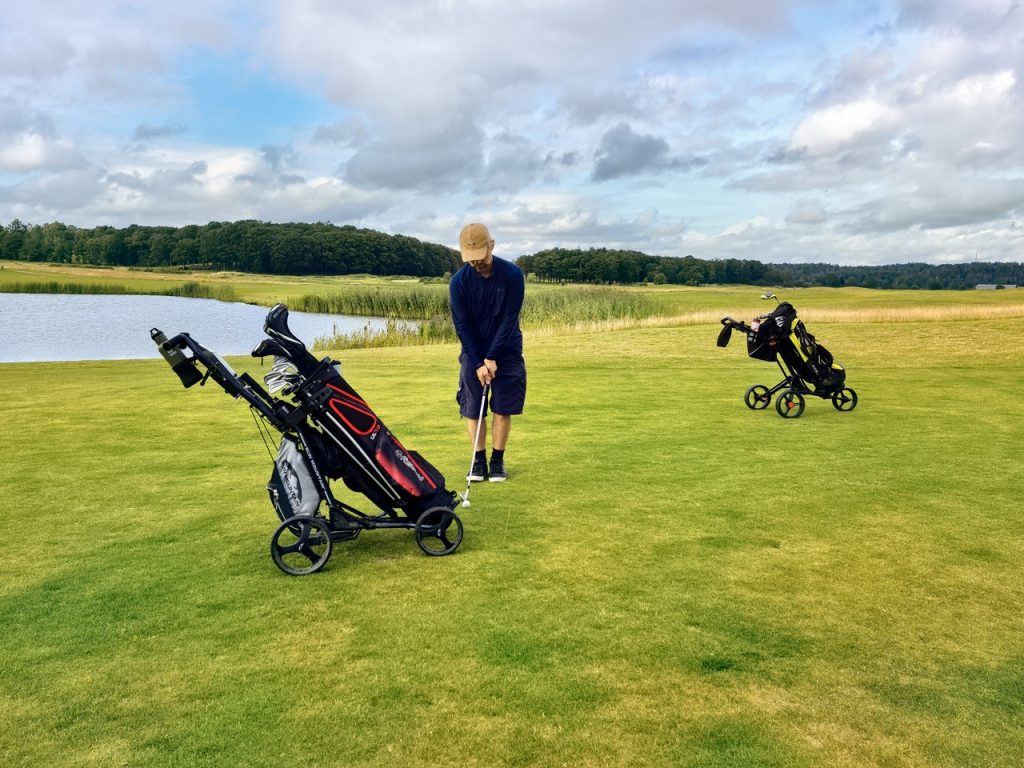 Man practicing ball striking drills on a golf course