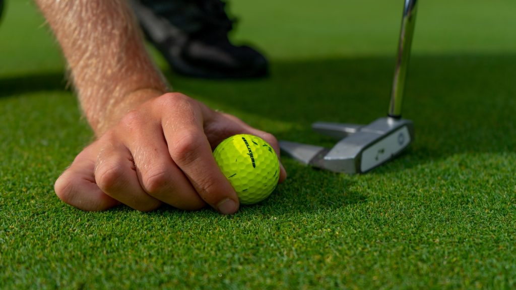 Man putting ball down for lag putting drills