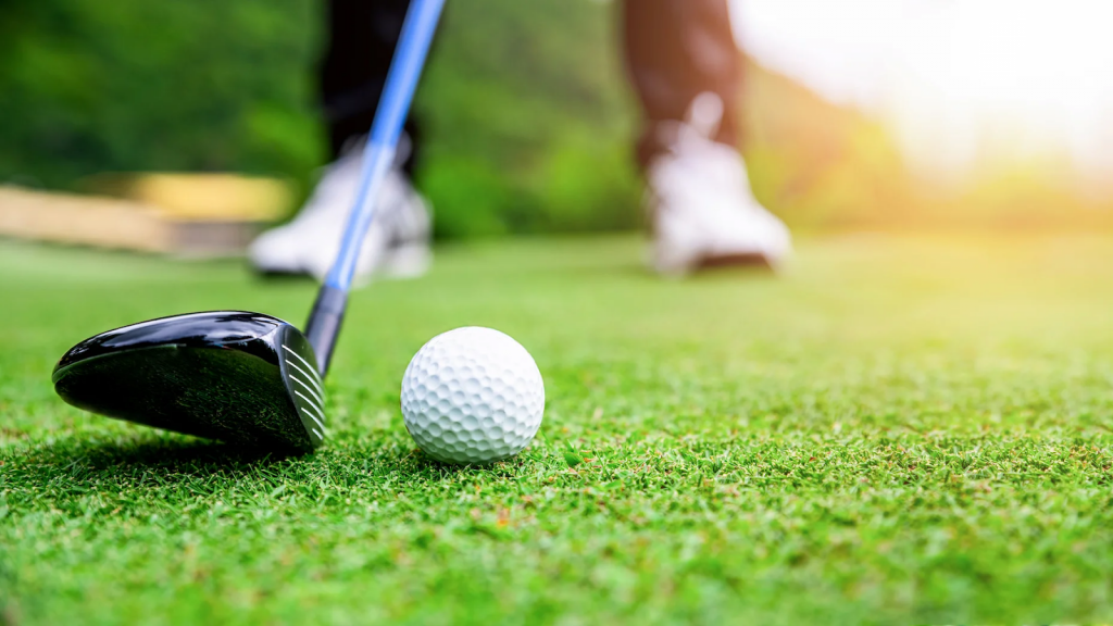 golf club about to hit ball on putting green