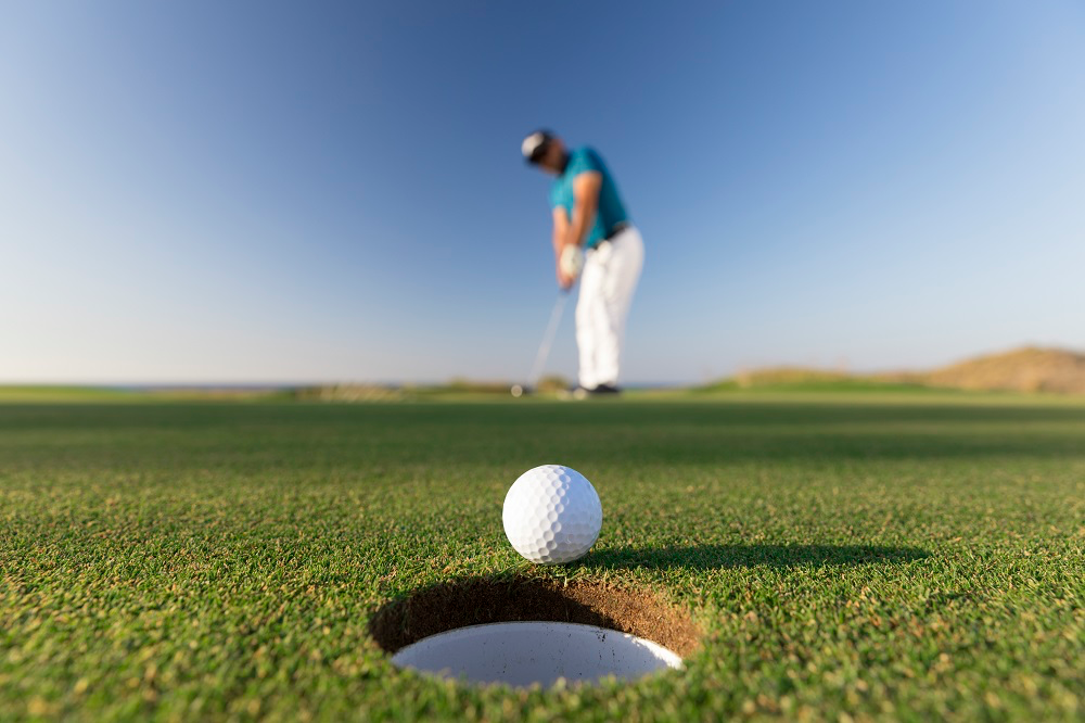 golfer hitting ball into hole