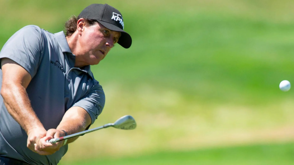 golfer using pitching wedge loft to hit golf ball