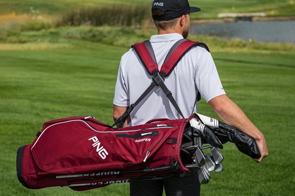 golfer with ping bag of golf clubs on back